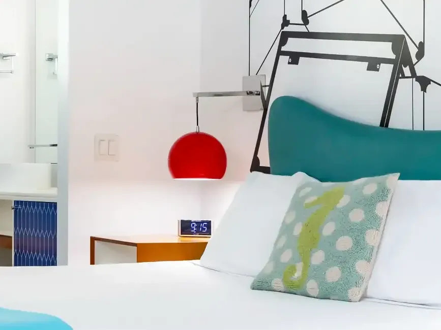 Galaxie King room at The Vagabond Hotel Miami with turquoise headboard and red bedside lamp