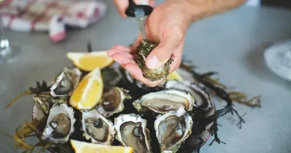 A man shucks a plate of fresh Tasmanian oysters