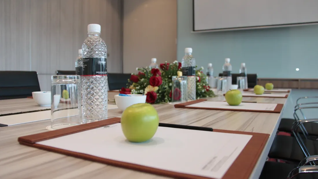 Meeting and Event Packages table set up with flowers, apples, and water bottles.