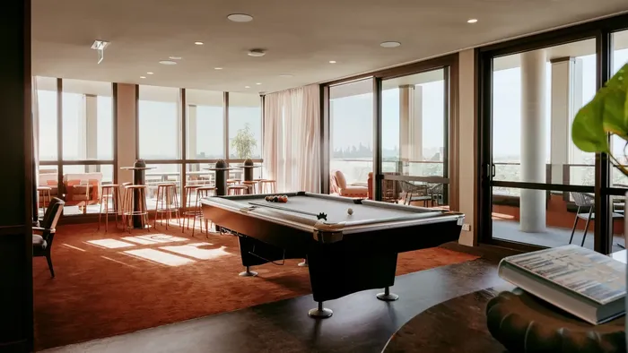 Common area with pool table and large windows.