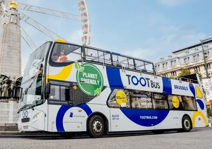 Tootbus Brussels tour bus parked on a cobblestone street near Warwick Grand Place Brussels