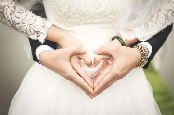A bride and groom form a heart shape with their hands - Grand Lexis Port Dickson