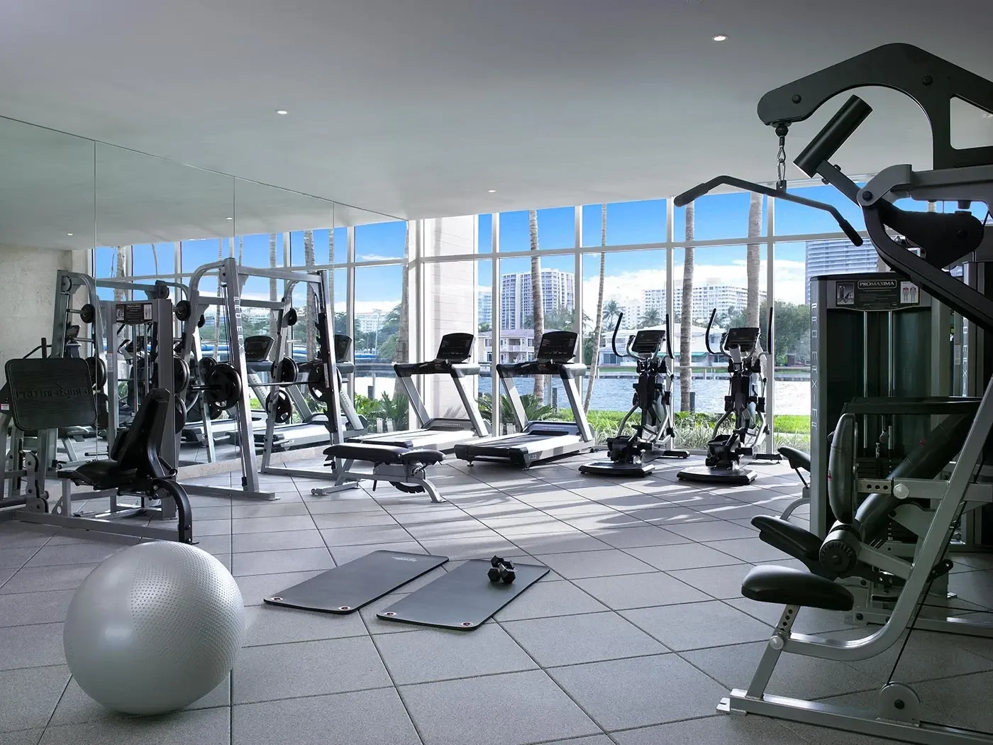 A well-equipped gym with a view of the city and water