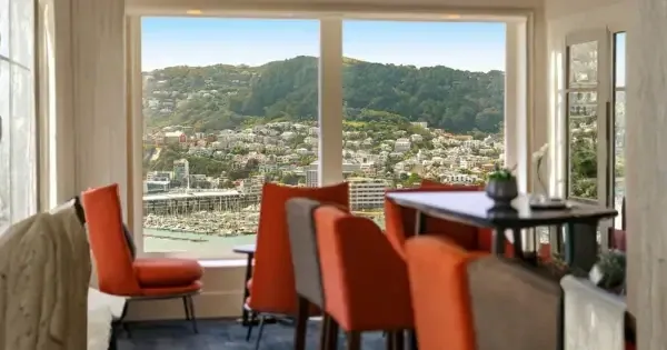 Harbour views from large bay windows, inside orange and brown chairs and a brown table