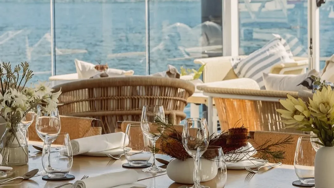 Upscale waterfront dining table set with fine stemware and white florals in Ormeggio at The Spit near Elysium Manly