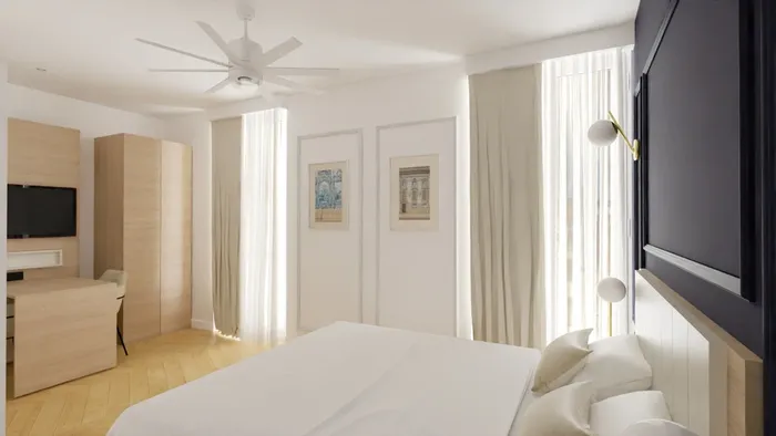 Chambre élégante avec lit, bureau, ventilateur et œuvres d'art au mur de Les Sources Callou.