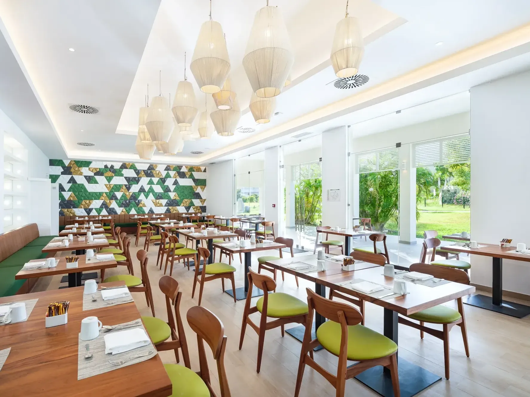 Bright and modern Market Café interior with green chairs and wooden tables at Saint Martin Beach Resort & Spa