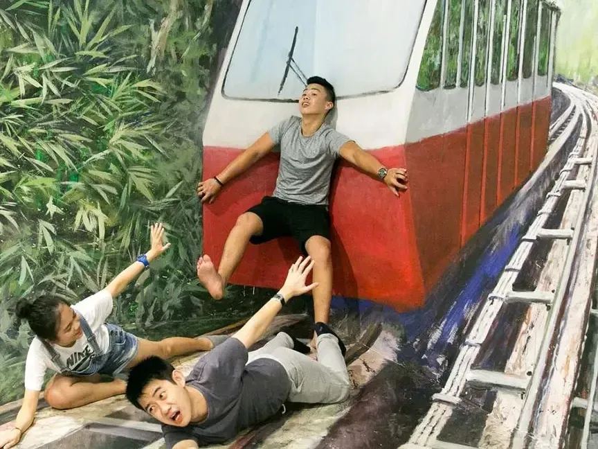 Three visitors striking a creative pose at the Made in Penang Interactive Museum - Lexis Suites Penang