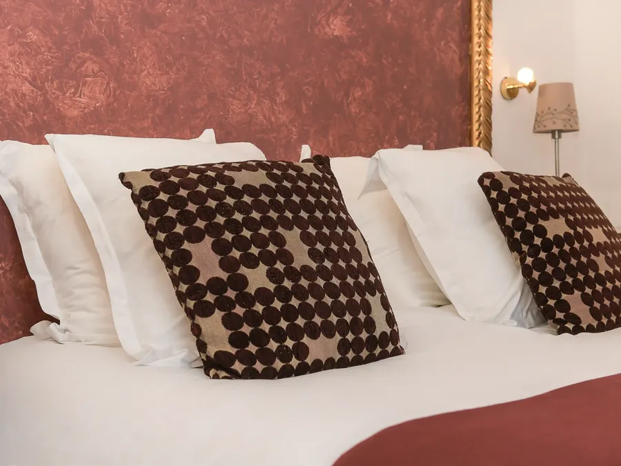 Lit avec oreillers et couverture dans la Chambre Confort à Hôtel Villa Aultia, Ault.