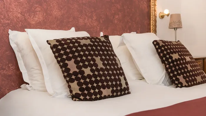 Chambre avec lit, oreillers et couverture à l'Hôtel Villa Aultia.