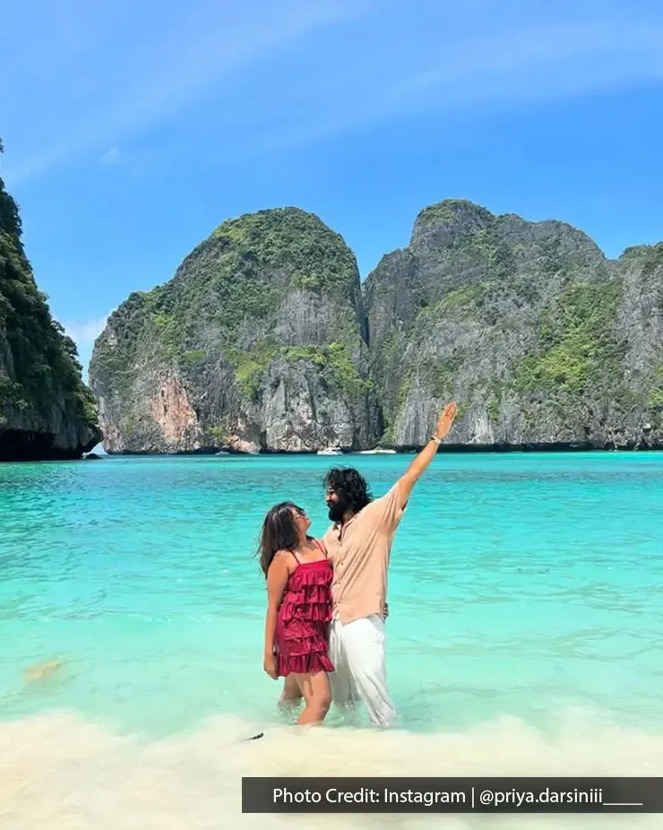 A couple standing on the beach with a scenic sea and mountain background - Lexis MY