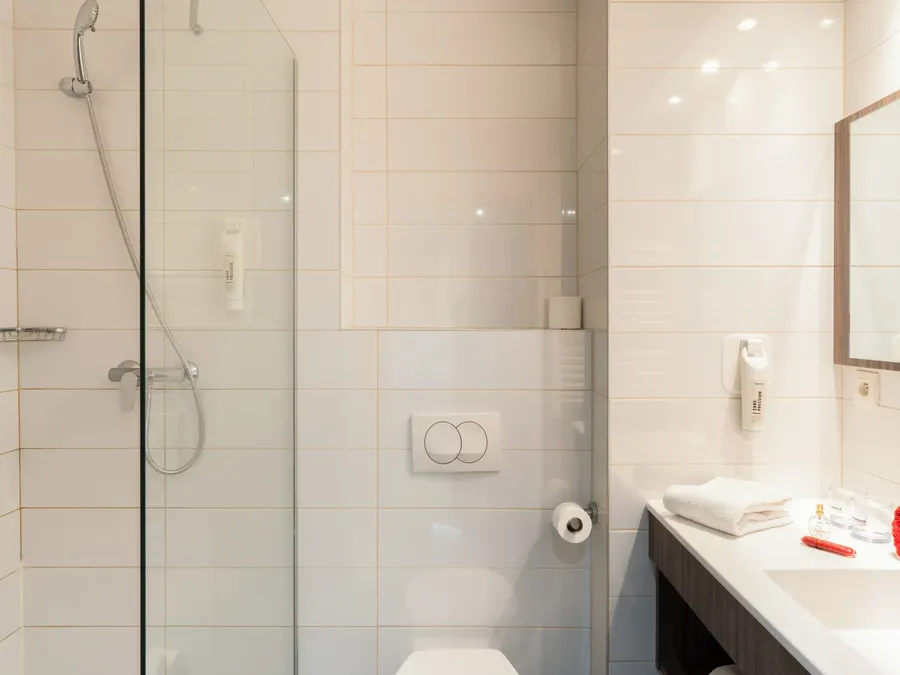 Modern bathroom with shower, toilet, and sink in Superior Studio at Appart’Hôtel Hévéa in Valence.