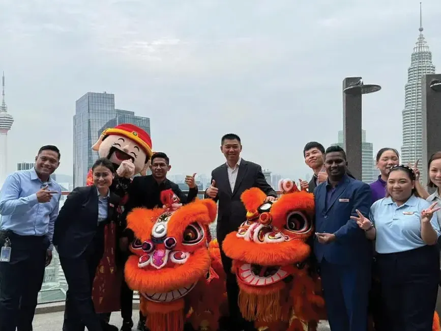 A group of lexis staff posing with lion dance group during chinese new year - Lexis Hotels & Resorts