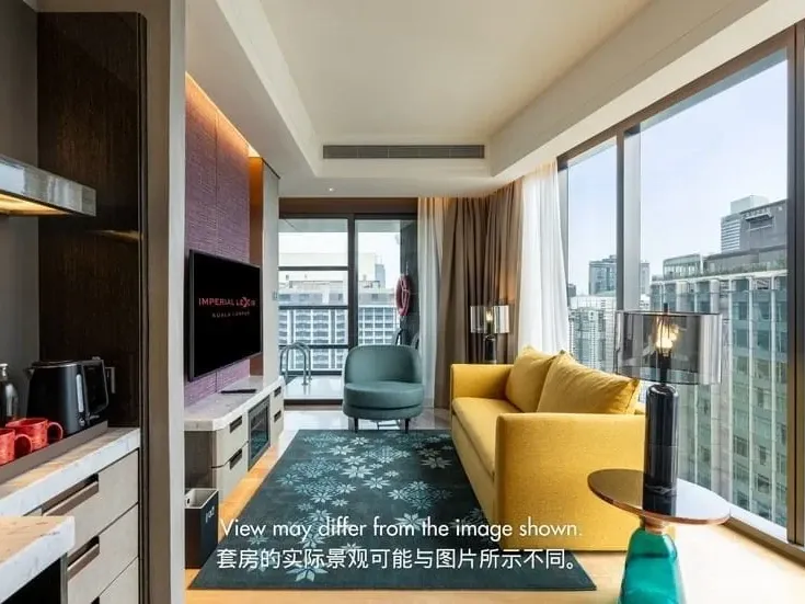 Modern luxury hotel suite living room with floor-to-ceiling city views, ideal for a premium KL staycation.