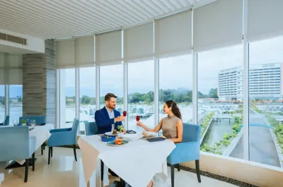 Couple toasting with drinks at Wave Dining with view - Lexis Hibiscus Port Dickson