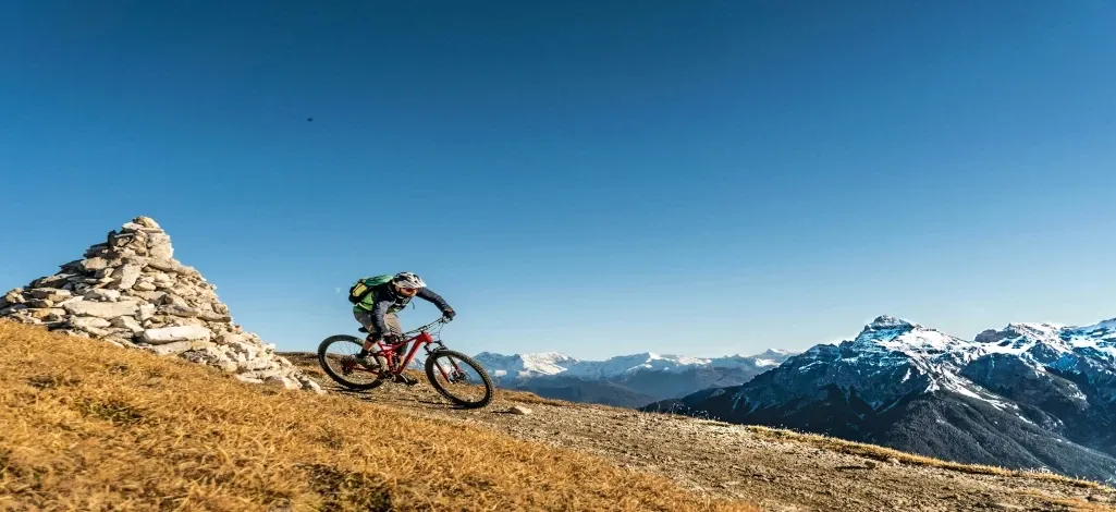 A person mountain biking down a trail on a mountain near Canmore.