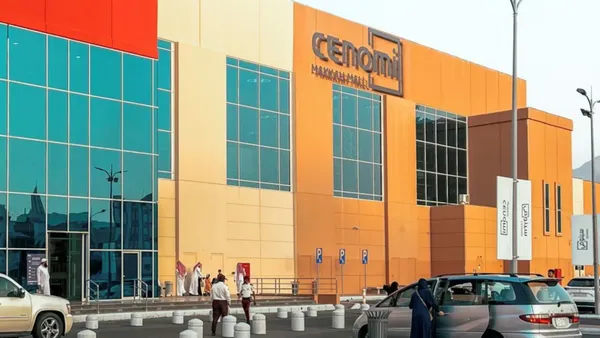 Vue extérieure du centre commercial Cenomi Makkah, avec des clients et des voitures garées près de l'hôtel Saja by Warwick Makkah