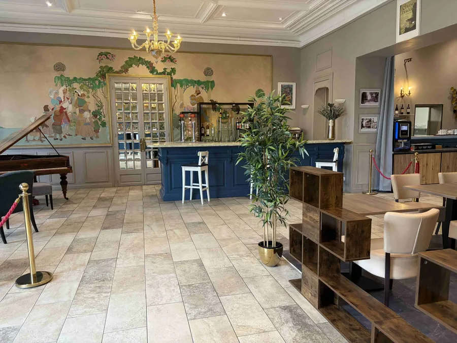 Salon élégant avec bar, piano et meubles en bois chez Le Grand Hôtel Molière