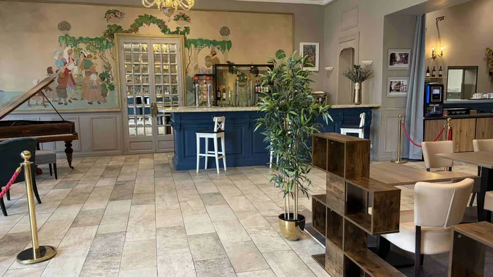 Salon élégant avec bar, piano et meubles en bois chez Le Grand Hôtel Molière