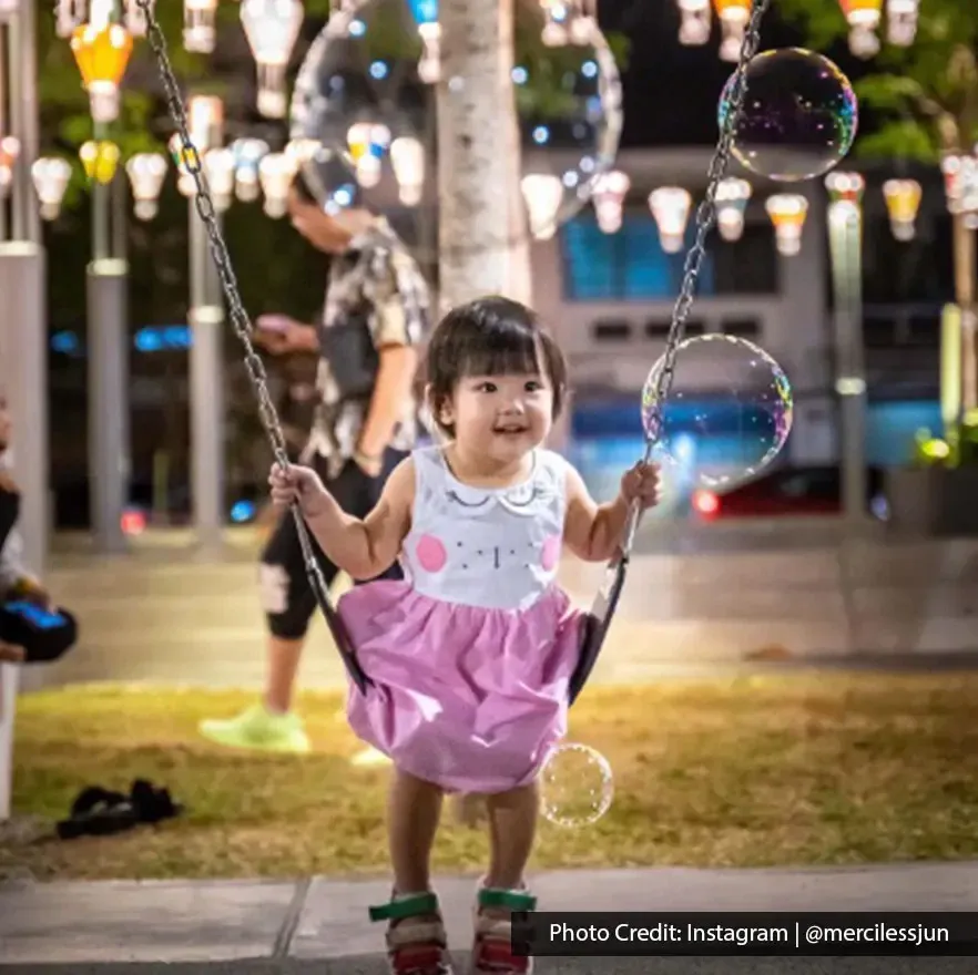 Little girl playing on a swing at Sia Boey Urban Archaeological Park.