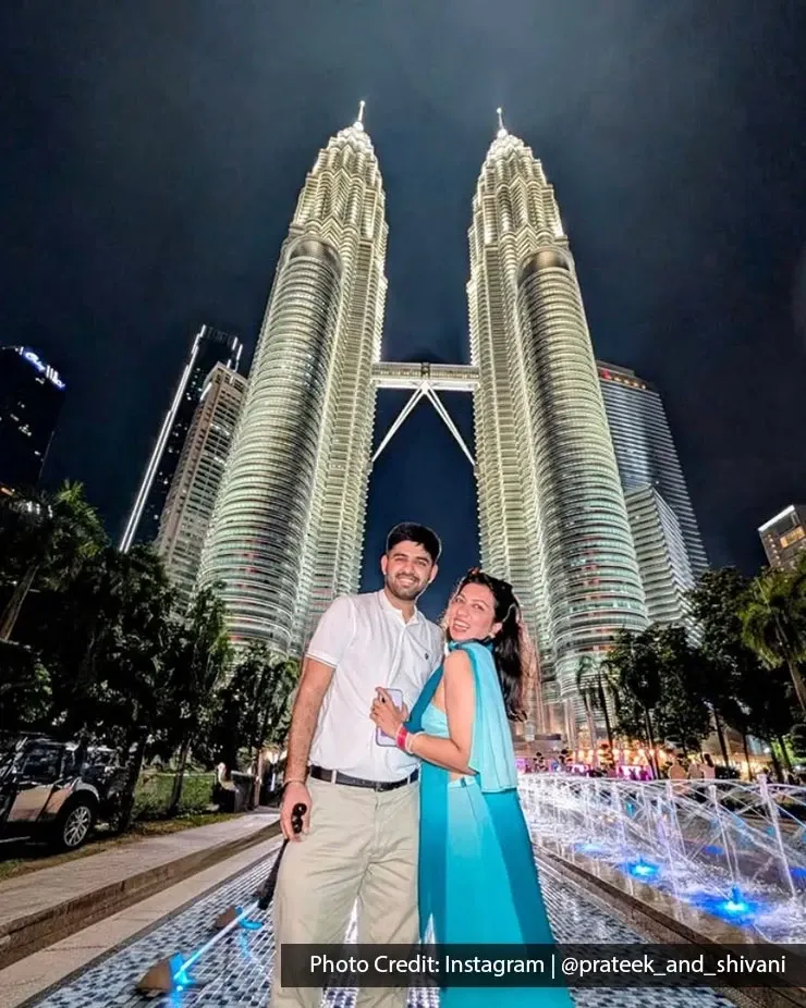 Couple posing in front of the Petronas Twin Towers at night