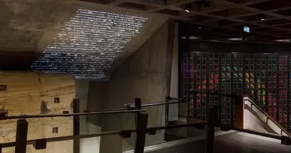 Modern museum interior with illuminated text projected onto a concrete ceiling