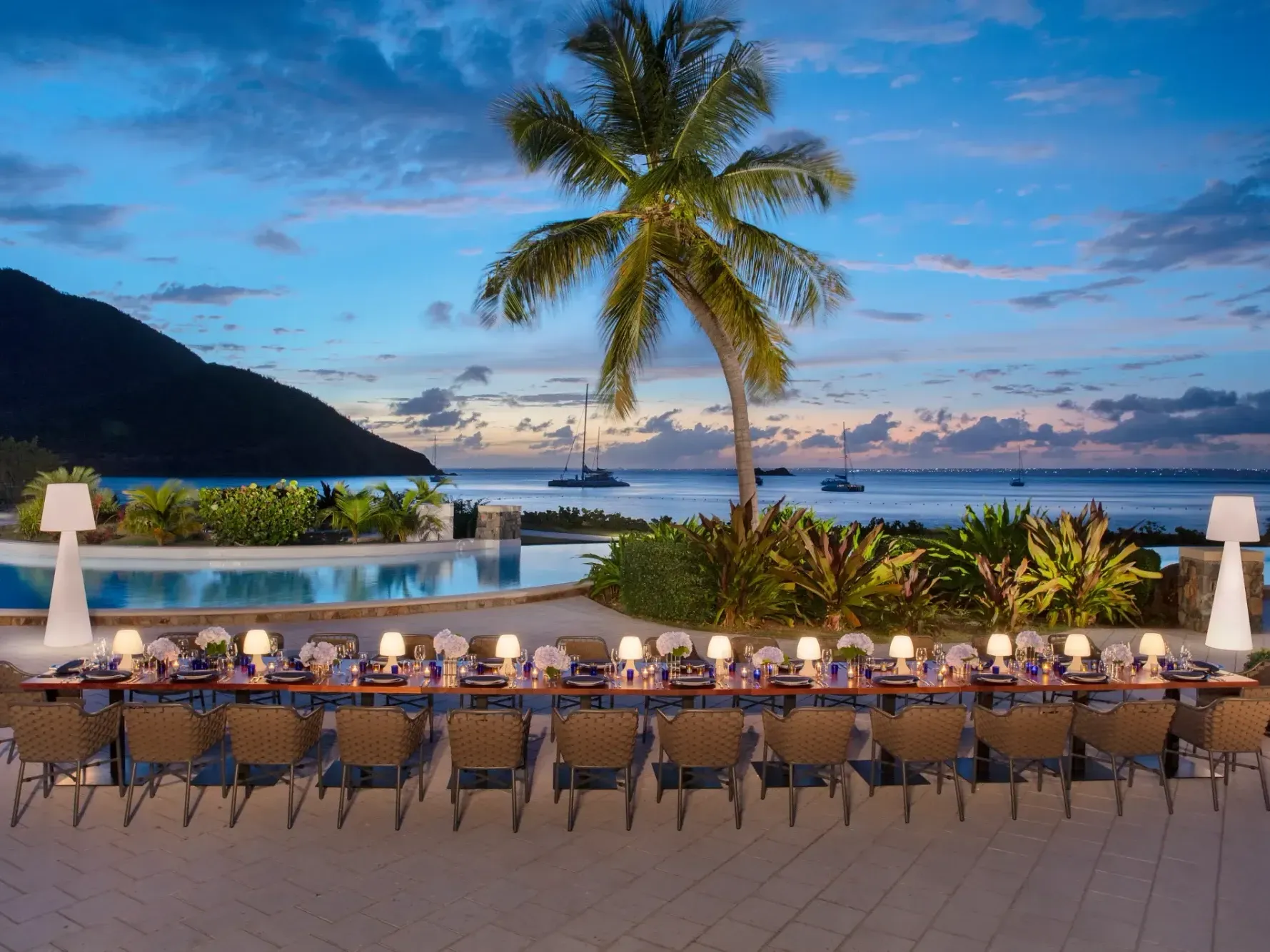 Beautiful beachfront private dining experience at Saint Martin Beach Resort & Spa, with a long table and glowing lanterns