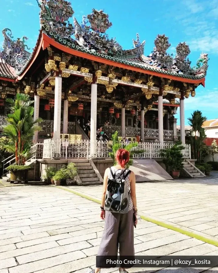 Tourist exploring historic Leong San Tong Khoo Kongsi heritage site in George Town Penang.