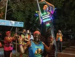 Performer on stilts in an LED costume entertaining crowd at night near the Jamaica Pegasus Hotel