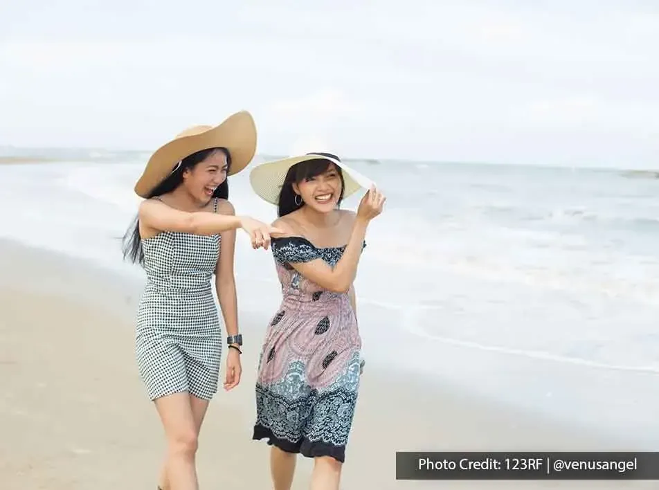 two girls strolling along the beach - Grand Lexis PD