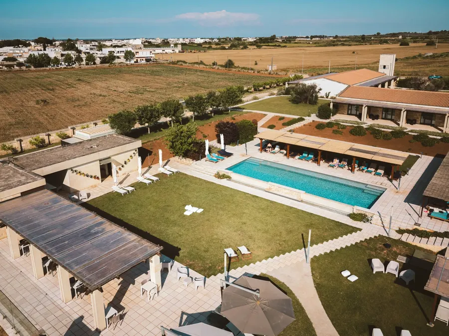 Vue aérienne de Masseria Stali montrant une piscine, des jardins et des bâtiments dans un cadre rural.