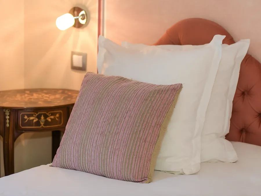 Lit avec oreillers et table de nuit à l'Hôtel Villa Aultia à Ault.