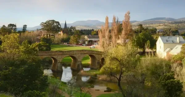 stone bridge in hinterlands surrounded by trees, lake and scattered houses