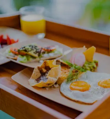 Delicious in-room dining breakfast tray with fried eggs and savory dishes at The Whitehall Houston