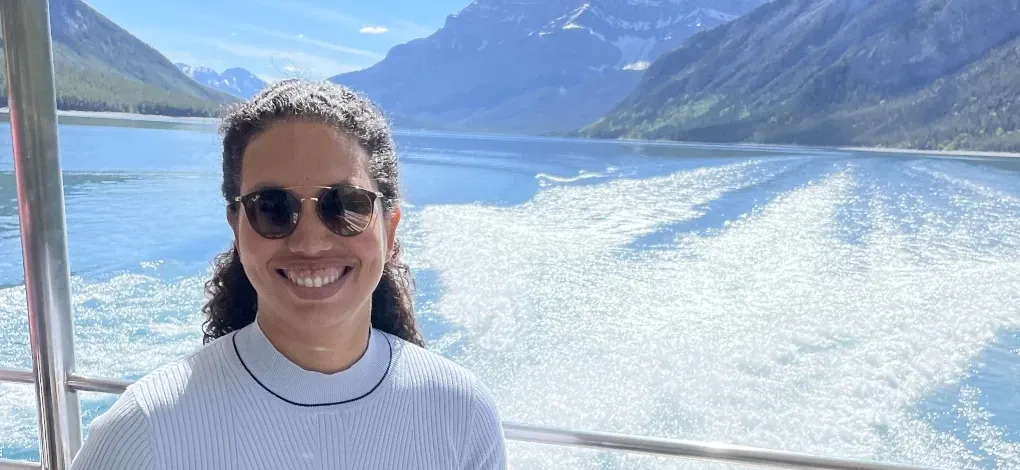 Person poses on a boat on a lake near Canmore