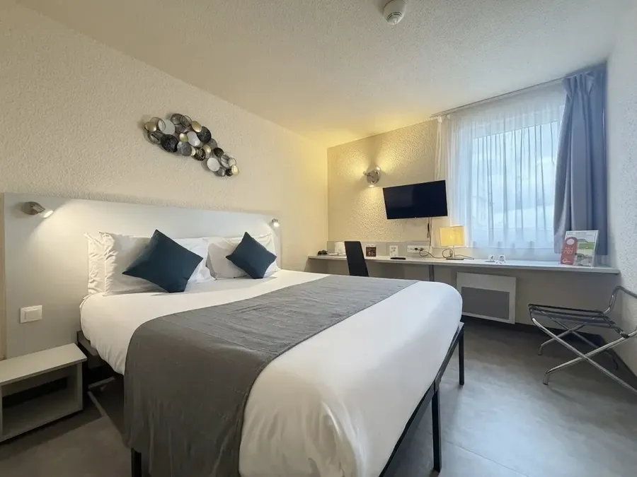 Chambre Confort Double avec lit double, bureau, télévision murale et décoration moderne à l'Hotel Le Forum Schiltigheim