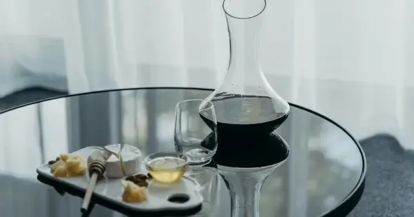 Red wine decanters next to a board of fresh Tasmanian cheeses and charcuterie