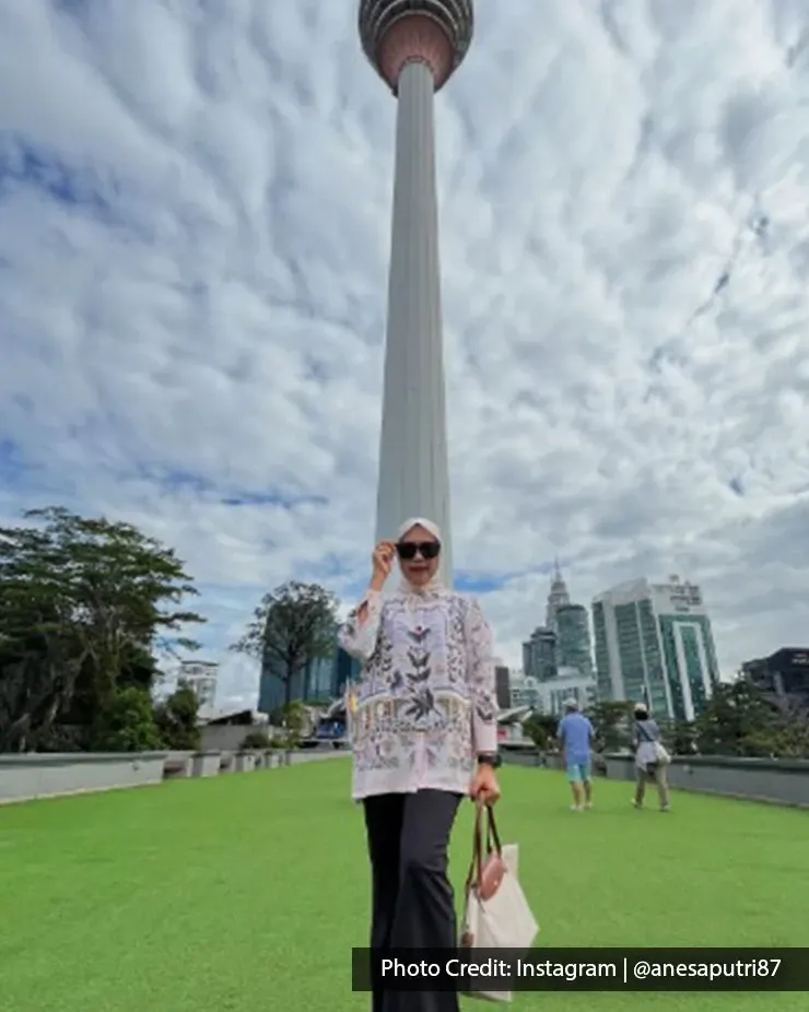 Woman posing in front of KL Tower in Kuala Lumpur