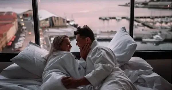 Couple relaxing in bed with waterfront views at Hotel Grand Chancellor Hobart