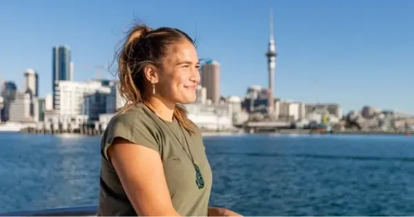 Woman enjoys views of Auckland from the harbour