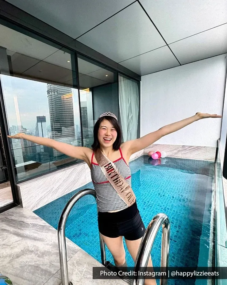 Woman enjoying her birthday celebration in a hotel room with private pool.