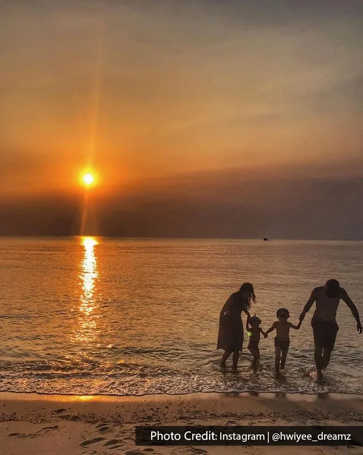 Parents and children enjoying the sea during sunset in Port Dickson