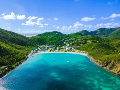 Vue aérienne de Saint Martin Beach Resort & Spa, entouré de la paisible baie d'Anse Marcel et de collines verdoyantes.