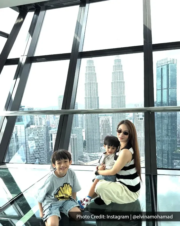 Mother and children posing indoors with Kuala Lumpur skyline view at Imperial Lexis Kuala Lumpur.
