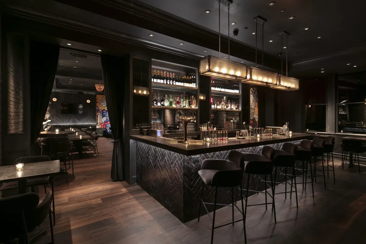 a dimly lit bar with a long counter and several stools