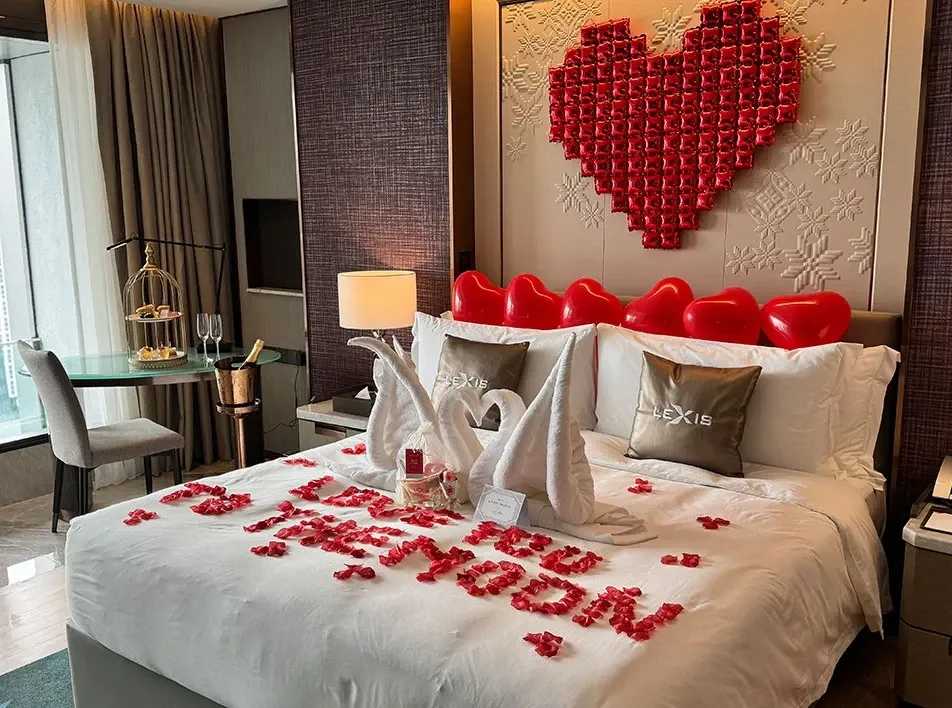A romantic bed featuring a heart-shaped headboard and pillow, perfect for a romantic staycation in KL with the Forever Yours Package.