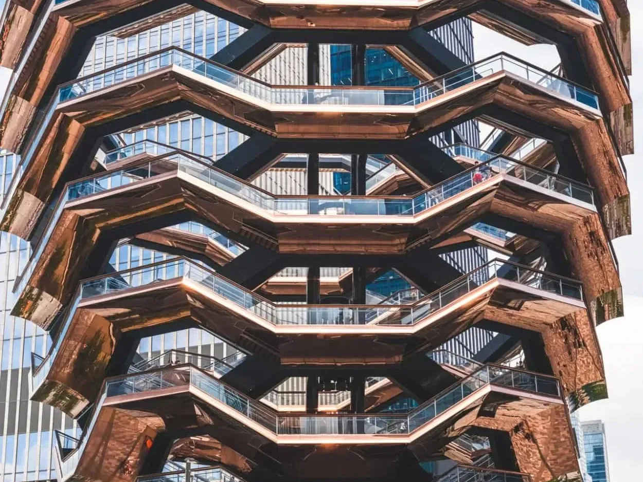 Exterior view of Hudson Yards featuring bronze-colored steps and glass railing near Kixby Hotel