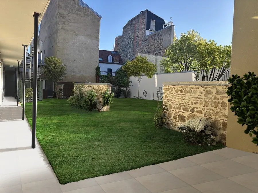 Jardin privé avec pelouse verte, murs en pierre et arbres au Flore Hôtel & Jardin