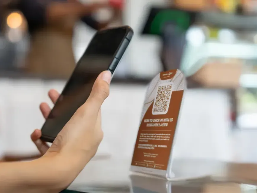 An individual using their phone to scan a QR code - Lexis Hotels & Resorts