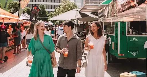 A group of people strolling through Brisbane City Markets.